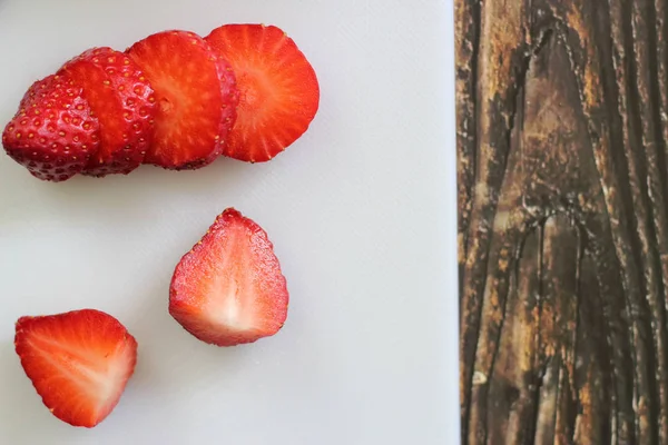 Strawberries on a white cutting board on a wooden background — Stock Photo, Image