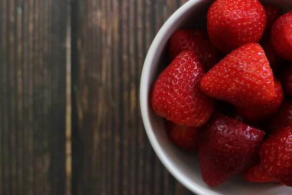 Top view strawberries in bowl on wood background — Stock Photo, Image