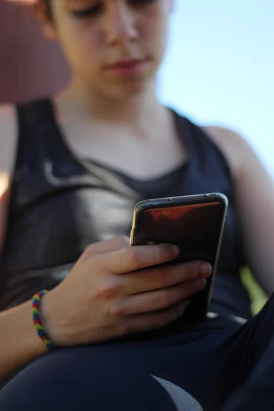 Remaja menonton ponsel selama istirahat setelah pelatihan — Stok Foto