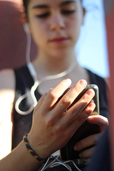 Tonåring tittar på mobilen under en paus efter träningen — Stockfoto