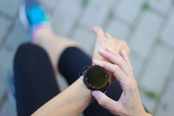 Wanita pelari memeriksa smartwatch sebelum latihan — Stok Foto
