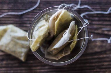 siyah ahşap masa üzerinde kullanılan çay poşetleri ile infuser