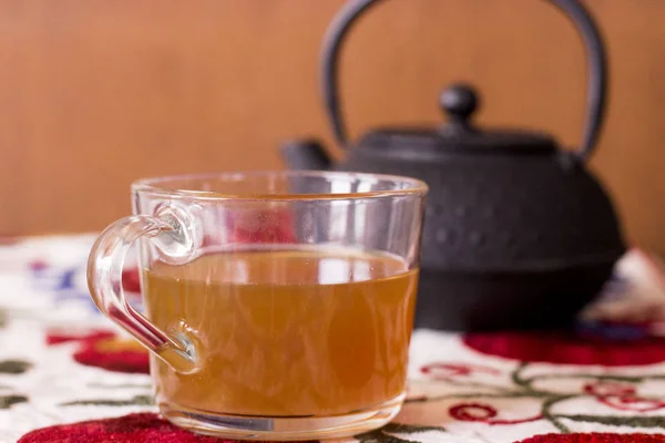 Despejando chá de um bule de chá em uma xícara de chá — Fotografia de Stock