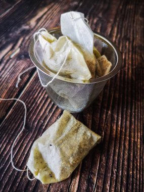 siyah ahşap masa üzerinde kullanılan çay poşetleri ile infuser