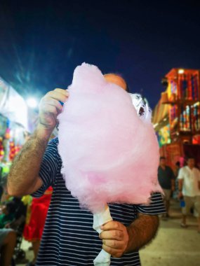 parkta pamuk şeker yiyen adam