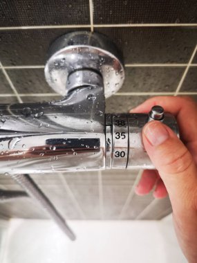 bir duş sıcaklığını düzenleyen el