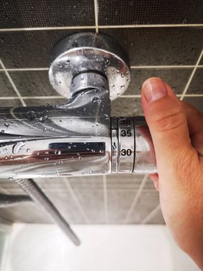 bir duş sıcaklığını düzenleyen el