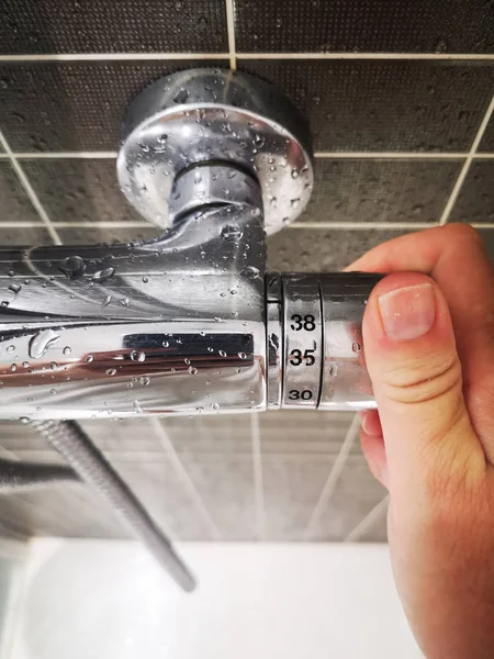 bir duş sıcaklığını düzenleyen el