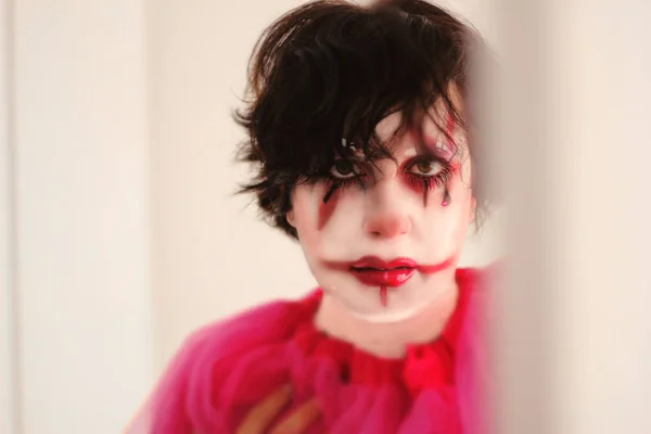girl with makeup and disguised as a bloody clown