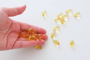Beyaz arka planda el tutma omega 3 hapları