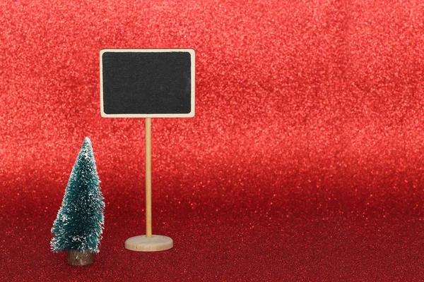 Small tree and blackboard signal decoration on glossy red background — Stock Photo, Image