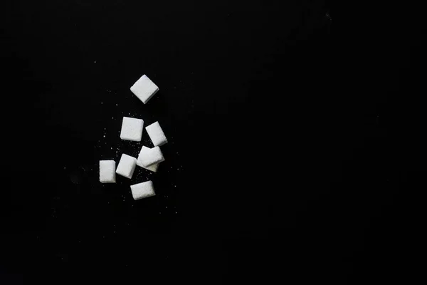 Vista superior de los cubos de azúcar blanco sobre fondo negro —  Fotos de Stock
