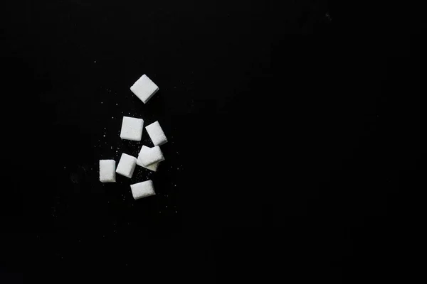 Ovanifrån av vitt socker kuber på svart bakgrund — Stockfoto