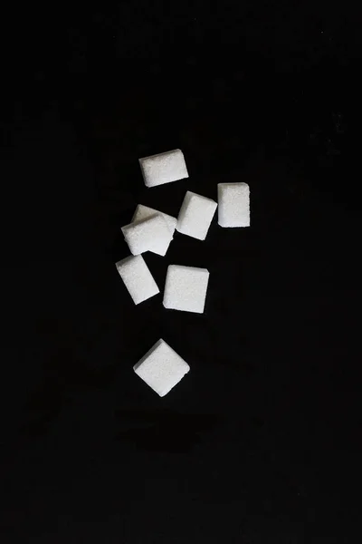 Vista superior de los cubos de azúcar blanco sobre fondo negro —  Fotos de Stock