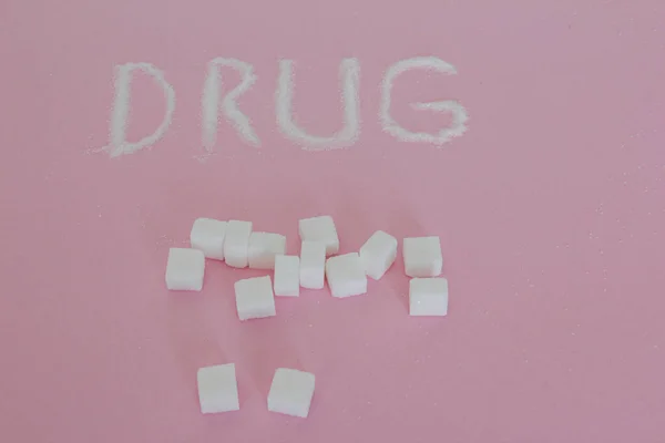Obat yang ditulis dengan gula batu pada latar belakang merah muda Stok Foto Bebas Royalti