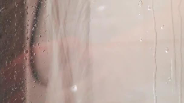 No chuveiro, a água caindo através de um copo fumegante da tela do chuveiro — Vídeo de Stock