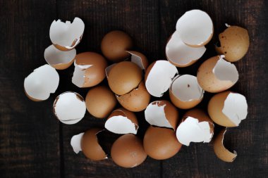 Ahşap masa arkasında kırık kahverengi yumurtalar.