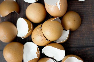 Ahşap masa arkasında kırık kahverengi yumurtalar.