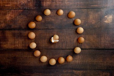 Kırık yumurta kabukları ahşap bir arka planda çember oluşturuyor.