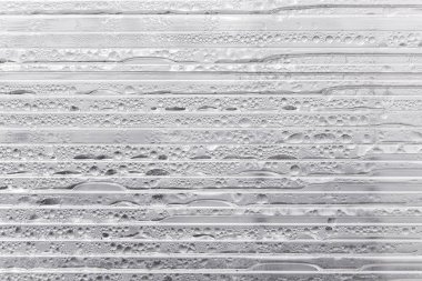 Yansıtıcı şeffaf plastik şal üzerinde su damlası. Damla doku. Yatay plakalar. Sera içinde yoğuşma.