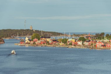 İsveç'te birçok balık tutma kentlerinden biri. Kırmızı ev rahat bir İskandinav beldesi. Yumuşak güneşli Altın ışık. Denizden görüntülemek.