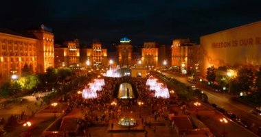 Bağımsızlık Meydanı. 1 Mayıs 2018. Kiev (Kiev). Ukrayna. Havadan görünümü çeşmeler. İyi akşamlar. İnsanlar Meydanı çevresinde yürüyüş. Bina. Yolda araba var. Şarkı çeşmeler