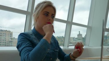 Sarışın kız olduğunu düşünüyor o yazmak gerekir ve yazmaya başlar. Kafede dizüstü bilgisayarda çalışan kadın.