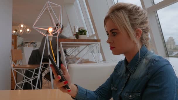 Ein Mädchen Einem Café Blickt Ein Smartphone Arbeit Auf Dem — Stockvideo