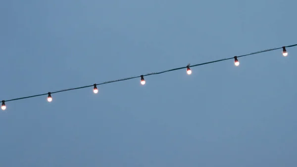 Blauwe Hemelachtergrond Elektrische Garland Voor Verlichting Met Witte Lampen Tegen — Stockfoto