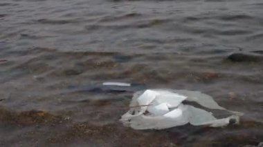 Dinyeper Nehri 'nin dibinde cam şişe şarap ve beyaz plastik torba. Çevre kirliliği. 4k görüntüleri