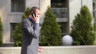 Genç bir işadamı sokakta yürürken agresif bir telefon görüşmesi bir tartışma yol açar. Klasik takım elbiseli adam akıllı telefonda konuşarak öfkegösteriyor. 4k görüntü.