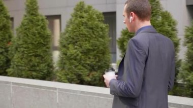 Kablosuz kulaklıkla yürüyen ve agresif bir şekilde telefon görüşmesine öncülük eden genç bir işadamı. Elinde bir bardak kahve ile klasik takım elbiseli adam konuşarak öfke gösterir.