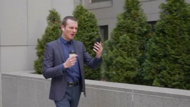 Genç işadamı kablosuz kulaklıklar ile gelir ve agresif akıllı telefonda bir görüntülü görüşme üzerinde bir tartışma yol açar. Elinde bir bardak kahve olan bir adam video konferansında onun hoşnutlarını gösteriyor.