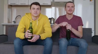 İki adam kanepede oturmuş futbol maçı izliyor ve bira içiyor. Zorluk la genç adam içki bir şişe açmak, arkadaşı ile bir fincan clinks ve Tv'de favori programı izlemeye başlar..