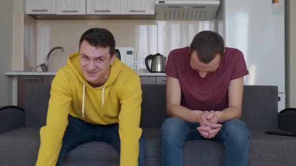Δύο Άντρες Χαμογελούν Νεαροί Αστείοι Τύποι Κάθονται Στον Καναπέ Και — Αρχείο Βίντεο
