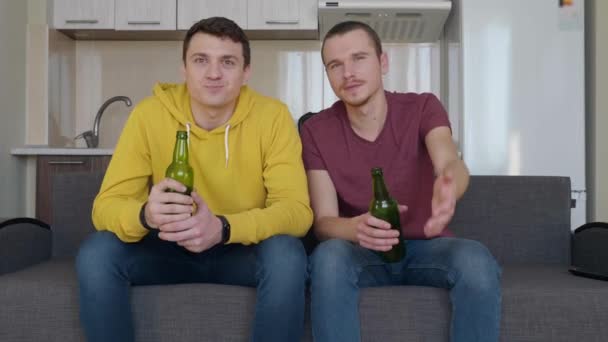 Dos Hombres Sentados Sofá Viendo Partido Fútbol Televisión Bebiendo Cerveza — Vídeo de stock