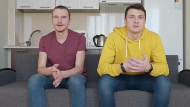 Dwóch Mężczyzn Siedzi Kanapie Ogląda Decydujący Moment Meczu Piłki Nożnej — Wideo stockowe