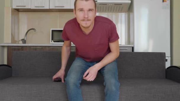Hombre Está Viendo Televisión Joven Sentado Sofá Tomando Control Remoto — Vídeos de Stock