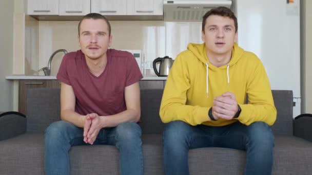 Zwei Männer Die Auf Der Couch Sitzen Schauen Sich Ein — Stockvideo