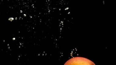 Sarı, kırmızı ve yeşil elmalar siyah zemin üzerinde şeffaf suya düşüyorlar. Akvaryumda taze meyve ve böğürtlen sıçraması. Organik meyveler, sağlıklı yemekler, diyet, hava kabarcıkları. Yavaş Hareket Yakın Çekim