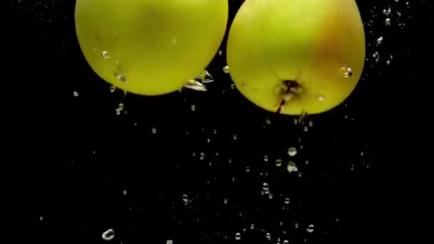 Δύο Κίτρινα Μήλα Που Πέφτουν Διαφανές Νερό Μαύρο Φόντο Φρέσκα — Αρχείο Βίντεο