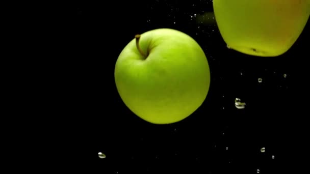 Pommes Jaunes Vertes Tombant Dans Eau Transparente Sur Fond Noir — Video