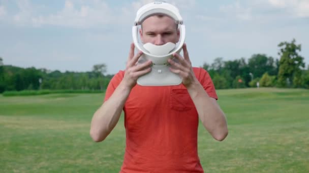 Hombre Pone Auricular Cabeza Parque Joven Con Una Camiseta Roja — Vídeos de Stock