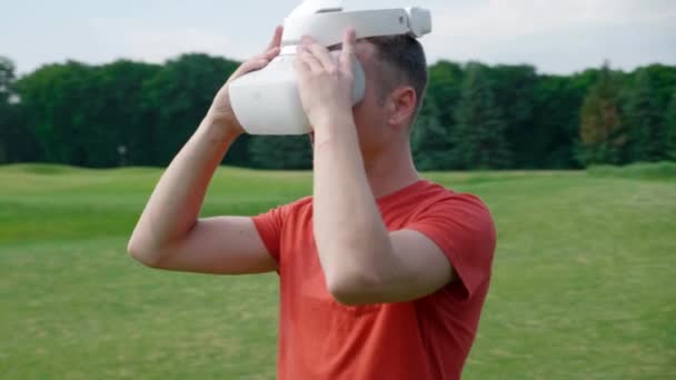 Hombre Pone Auricular Cabeza Parque Mira Alrededor Joven Con Una — Vídeos de Stock