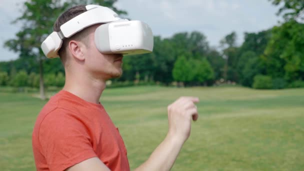 Egy Férfi Hozza Headset Fejét Egy Parkban Elkezdi Használni Aztán — Stock videók
