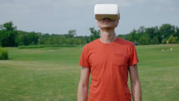 Человек Использующий Гарнитуру Виртуальной Реальности Парке Поворачивающий Голову Вверх Молодой — стоковое видео
