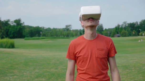 Een Man Die Een Headset Het Park Gebruikt Zijn Hoofd — Stockvideo