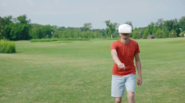 Bir adam VR kulaklık kullanarak ve parkta sanal bir oyun oynuyor. Kask genç adam doğanın arka planda artırılmış gerçeklik yaşıyor. Doğru çerçevede bir insan. 4k görüntüleri.