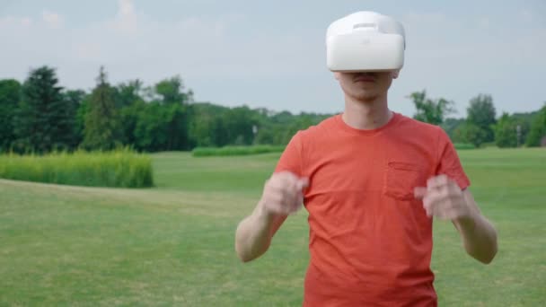 Man Puts Headset His Head Playing Virtual Game Park Young — Stock Video