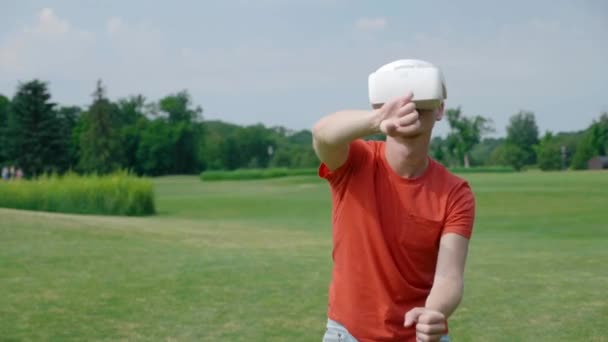 Человек Использующий Гарнитуру Играющий Виртуальную Игру Парке Молодой Парень Шлеме — стоковое видео